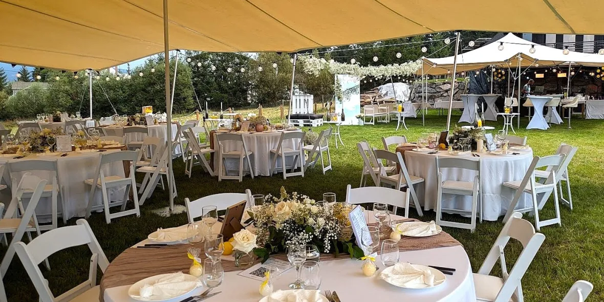 CORTURI AFRICANE PENTRU NUNTA TA DE VIS Mese rotunde cu scaune aranjate pentru o nuntă în aer liber, sub mai multe corturi africane închiriate, decorate cu ghirlande din floarea miresei (Gypsophila).